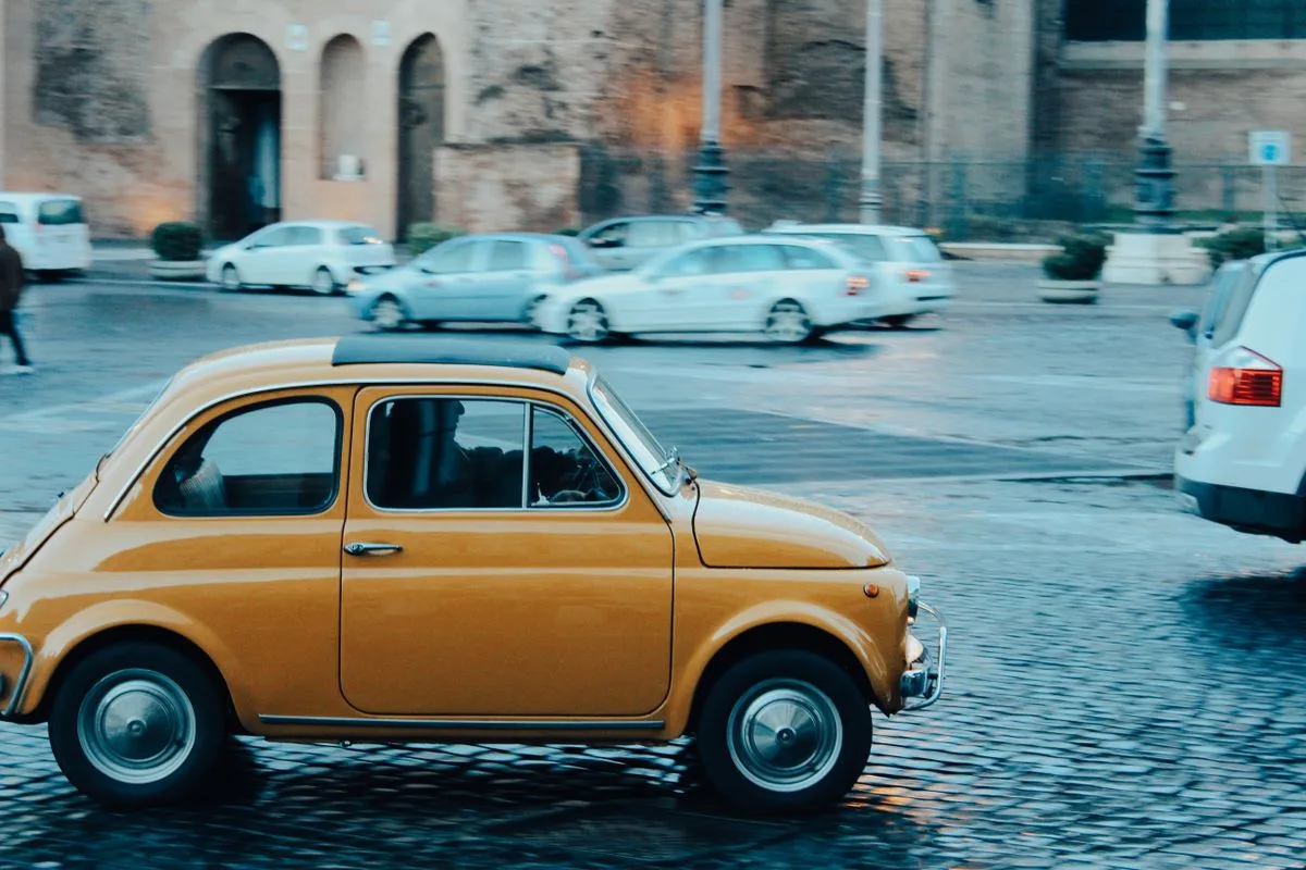 Fiat 500 d'epoca parcheggiata in una piazza italiana