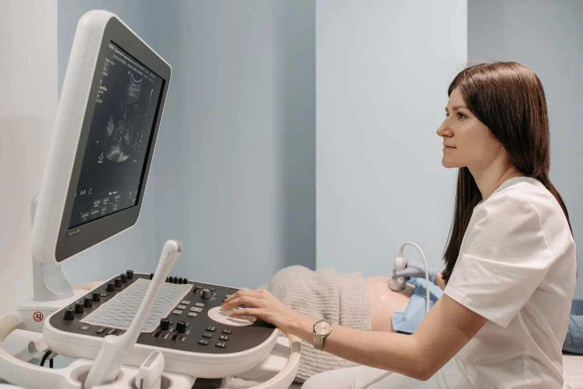 Medico che esegue un'ecografia a una donna incinta