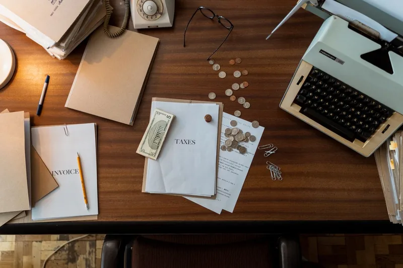 Scrivania vintage con macchina da scrivere, monete e documenti