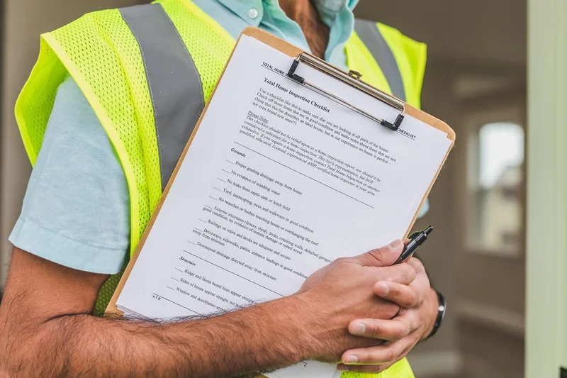 Tecnico con clipboard che controlla un documento di verifica