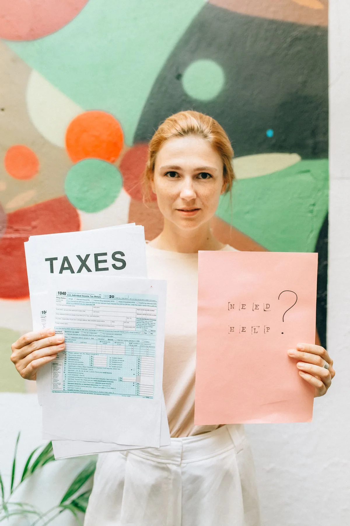 Donna che mostra un cartello con la scritta taxes e un modulo